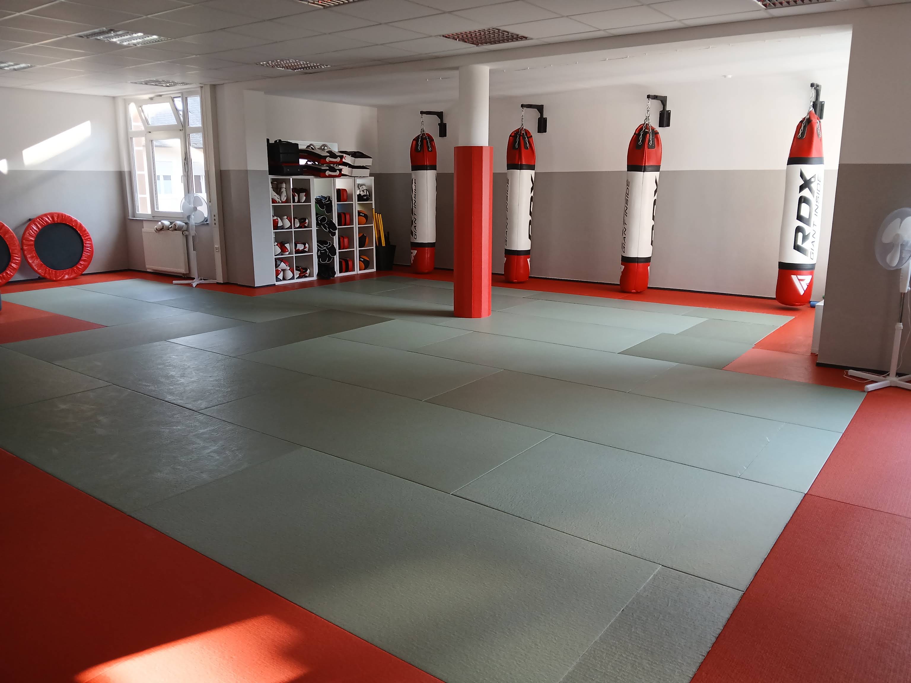 Trainingsraum der Kampfsportschule Germering mit Mattenfläche und Boxsäcken